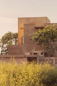 Concrete building exterior with green foliage in the foreground.
