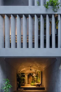Modern lounge area with concrete walls and ceiling, illuminated by warm lighting.