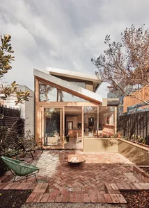 Modern exterior view of a home featuring brick, glass, and motion elements.