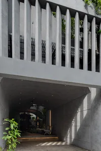 Concrete porch with plants and seating.