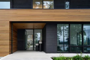 Modern house exterior with wooden cladding and large glass windows.
