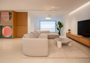 Modern living room with a concrete wall, white sofa, and minimalistic design elements.