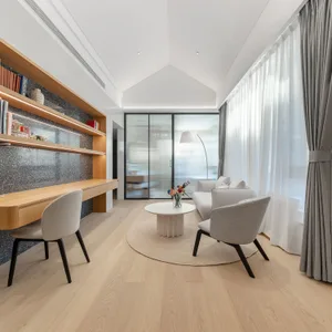 Modern minimalist living room with a white coffee table, gray armchairs, and a wooden floor.