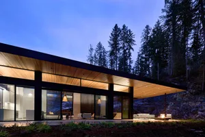 Modern residential building with large windows and wooden elements.