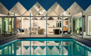 A modern residential interior design featuring a glass pool, with sleek furniture and an open-plan layout.
