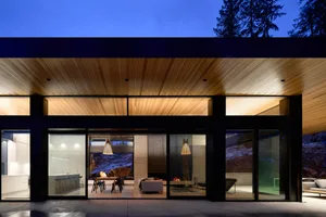 A modern residential space featuring mixed materials, including wood, glass, and metal.