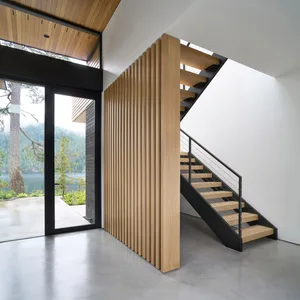 Modern minimalist interior design showcasing a staircase with wooden steps and metal railings.