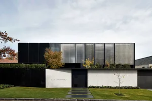 Modern residential exterior featuring concrete and glass materials.