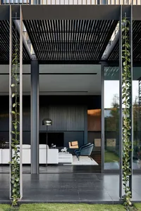 A modern living space with a metal frame, featuring a minimalist design with black and white tones and greenery