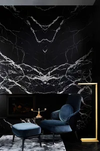 Modern living room featuring black marble accent wall and navy blue armchair