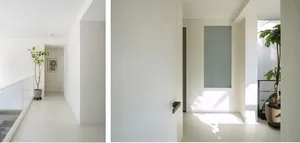 A minimalist interior space with white walls and concrete finishes.