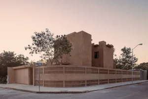 Minimalist modern residential building with a rough, textured concrete exterior.