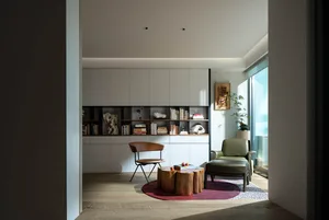 A minimalist living room featuring wooden furniture, leather accents, and glass decor, creating a warm and welcoming space.