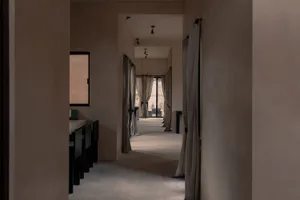 A minimalist lobby designed with concrete walls and gray fabric curtains.