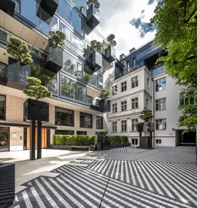 A modern commercial space with a glass facade and geometric courtyard.