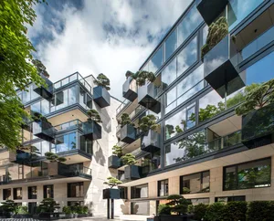 Modern high-rise building with glass windows and greenery