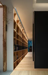 現代工業風圖書館，木質書架上擺滿書籍與植物。