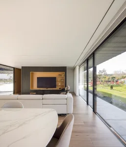 Contemporary living room featuring minimalist design, white marble flooring, and wood accents.