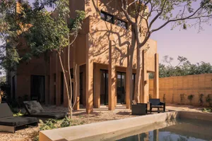 Modern minimalist home constructed of concrete with a small pool and garden.