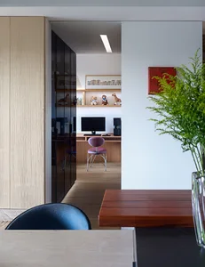 A modern office space with wooden furniture, featuring a desk, chair, and computer setup.