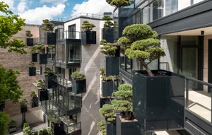 Modern residential development featuring green plants and concrete and glass structures