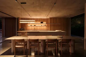 Modern residential kitchen with wooden cabinets and concrete floor.