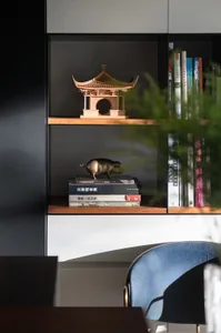 A minimalist wooden bookshelf with books and decorative items.