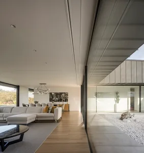 Modern minimalist living room featuring wood, glass, and concrete materials