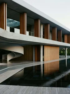A modern building with concrete, glass, and wooden elements.