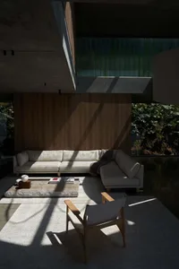 Contemporary living room with concrete walls, a minimalist sofa, and a stone coffee table.