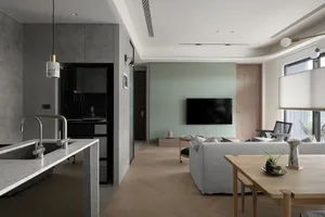 A modern living room featuring concrete walls, wooden flooring, and fabric couches.