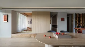 Modern minimalist living and dining space featuring wood elements.