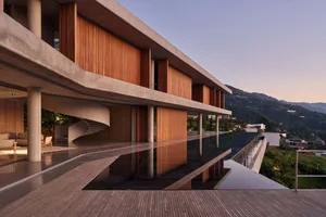 現代住宅建築採用混凝土牆面搭配木質元素，設有無邊際泳池，可眺望山景。