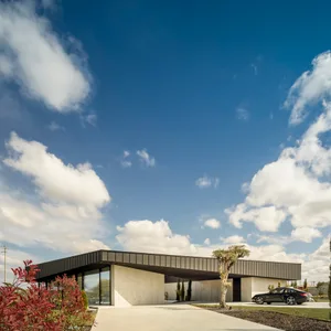 A modern residential home with a concrete exterior and large windows.