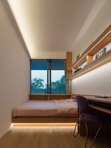 A minimalist bedroom featuring wooden furniture and a large window with a view of trees.