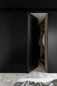 Modern interior view of a black closet with wood elements showing minimalist design