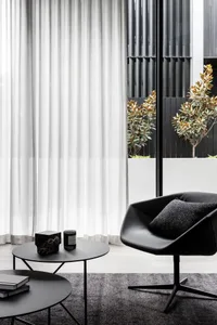 A modern living room featuring concrete and glass materials and minimalist decor.