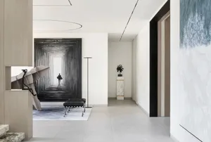 A minimalist corridor with a concrete floor and white walls.