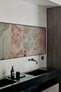 Modern bathroom featuring metallic cabinets against a sleek black countertop with a minimalist design.