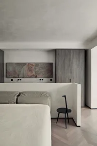 A modern bedroom features concrete walls and wooden furniture.