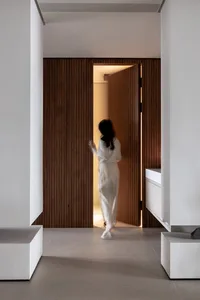 寬敞現代玄關，寬闊雙開門由優雅垂直木板框起，引導訪客進入