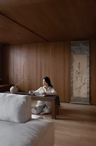 A modern living room with warm wooden elements, minimalist furniture, and a serene ambiance.