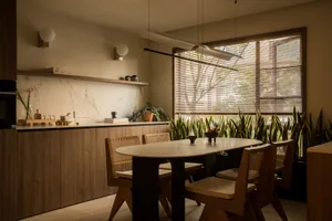 A modern kitchen dining room with a marble countertop and wooden furniture.