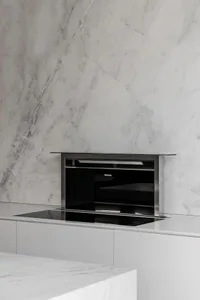 Modern kitchen with marble countertops, backsplash, and wall