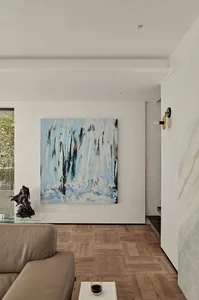 A modern living room featuring abstract artwork and wooden flooring.