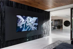A modern living room with a digital display mounted on the wall, showing an aerial view of a cityscape.