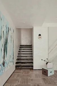 A modern staircase with black marble steps against a light-colored wall and a wooden floor. A large abstract painting hangs o