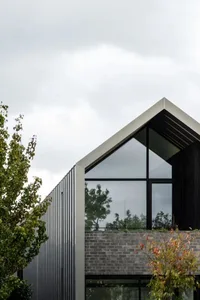 A modern metal-clad house with large windows.
