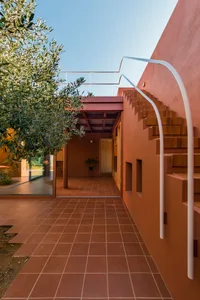 A modern residential building featuring exterior walls clad in red earthy bricks.