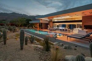 Modern residential exterior featuring sleek design with concrete, glass, and wood elements.